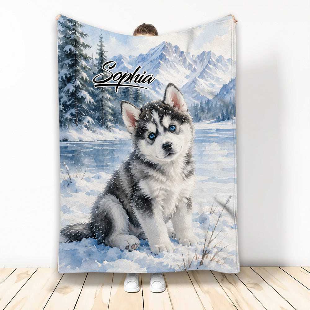 Husky blanket featuring a blue-eyed puppy in a snowy mountain and evergreen forest scene