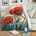 Dragonfly throw blanket with red poppy artwork styled on a sofa with books