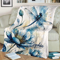 Close view of a dragonfly and blue flower watercolor blanket draped over a sofa