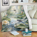 Dragonfly throw blanket displayed on a sofa with lotus pond artwork and tranquil nature colors