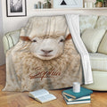 Sheep blanket draped over a sofa with a close-up lamb face and cozy neutral farm theme