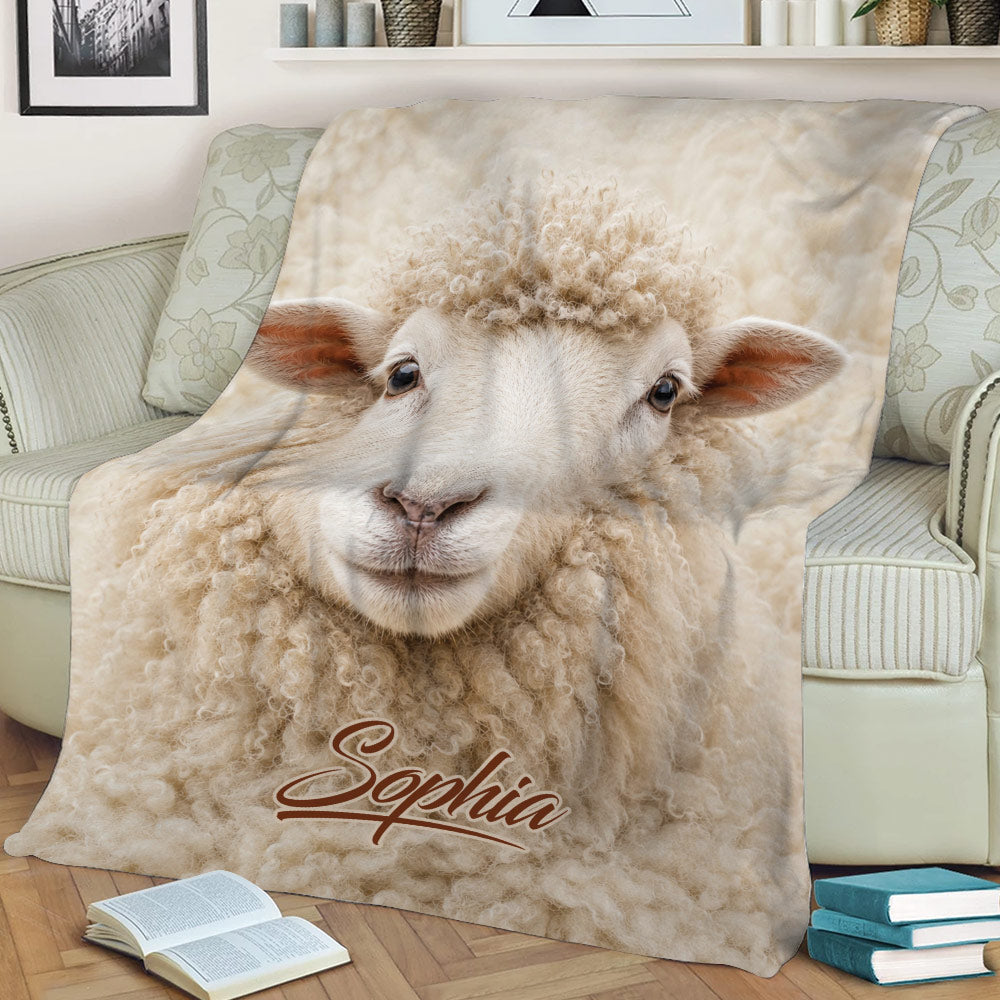 Close-up sheep throw blanket displayed on a sofa with soft cream-colored farm animal artwork