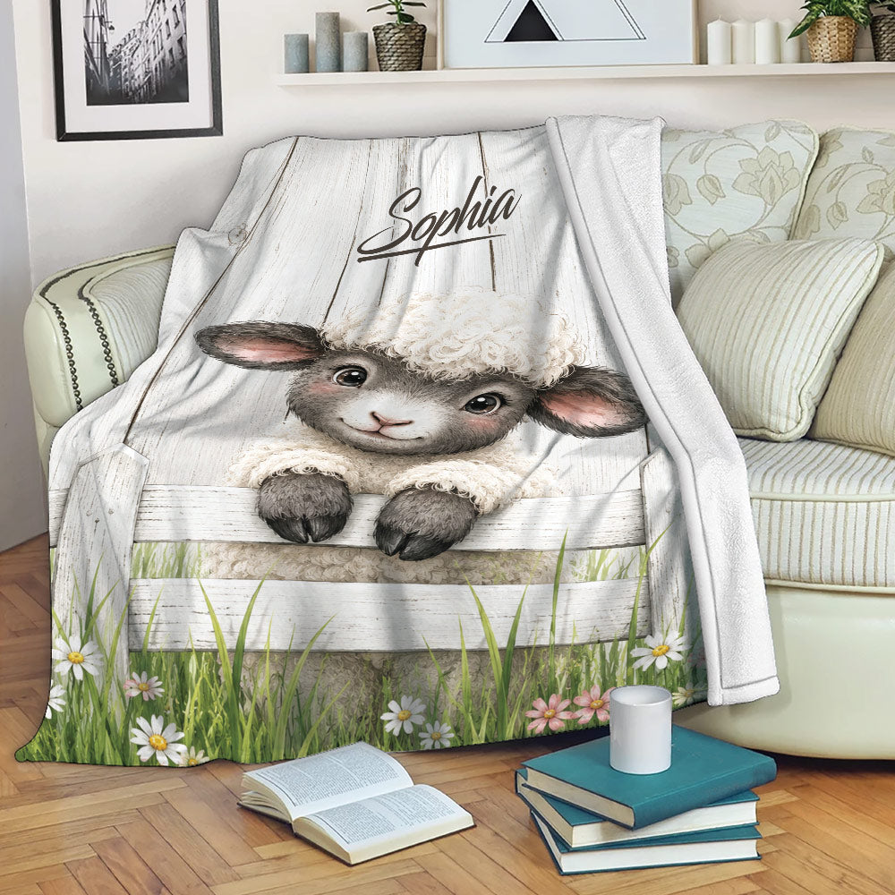 Sheep throw blanket displayed on a sofa with a sweet lamb, white fence, grass and flowers