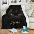 Black cat throw blanket draped over a sofa, creating a cozy reading nook with dramatic feline artwork