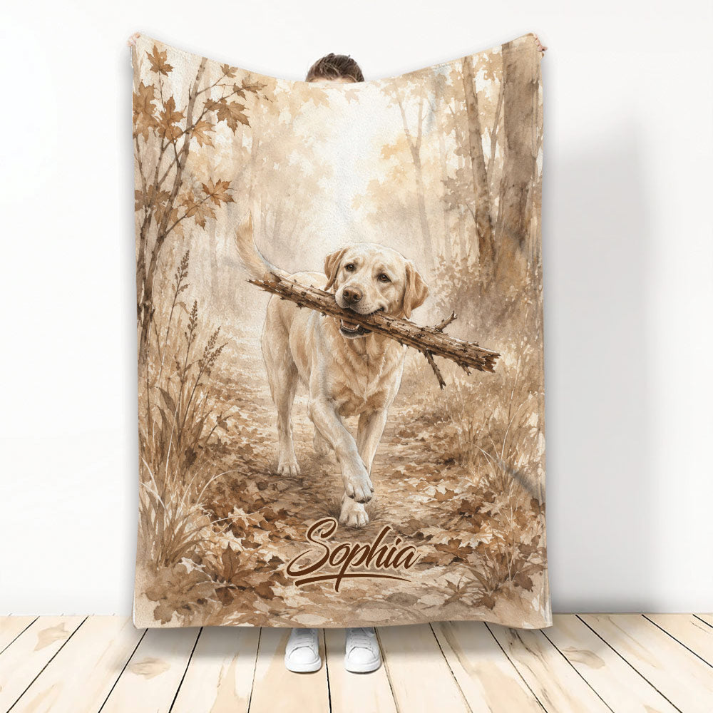 Labrador Retriever carrying a branch through an autumn forest on a rustic printed blanket