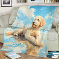 Beach-themed Goldendoodle blanket draped over a sofa with a curly dog resting by the ocean