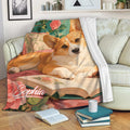Corgi throw blanket draped across a sofa with floral artwork and cozy reading decor