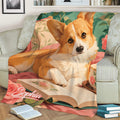 Close view of a Corgi throw blanket featuring floral artwork, an open book, and warm colors