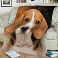 Close view of a Beagle throw blanket spread across a sofa with warm brown and black artwork