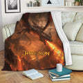 Fiery dragon blanket draped over a sofa with dramatic fantasy artwork
