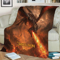 Dragon throw blanket styled on a sofa with glowing fire and fantasy landscape