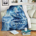 Blue fantasy dragon throw blanket draped over a sofa in a cozy reading space