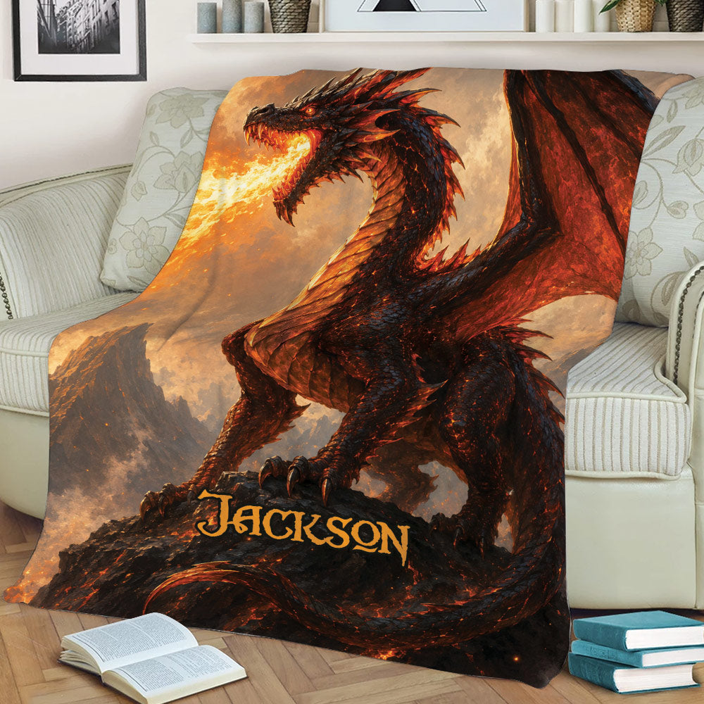 Dramatic dragon throw blanket displayed on a sofa with red wings, flames, and mountain artwork
