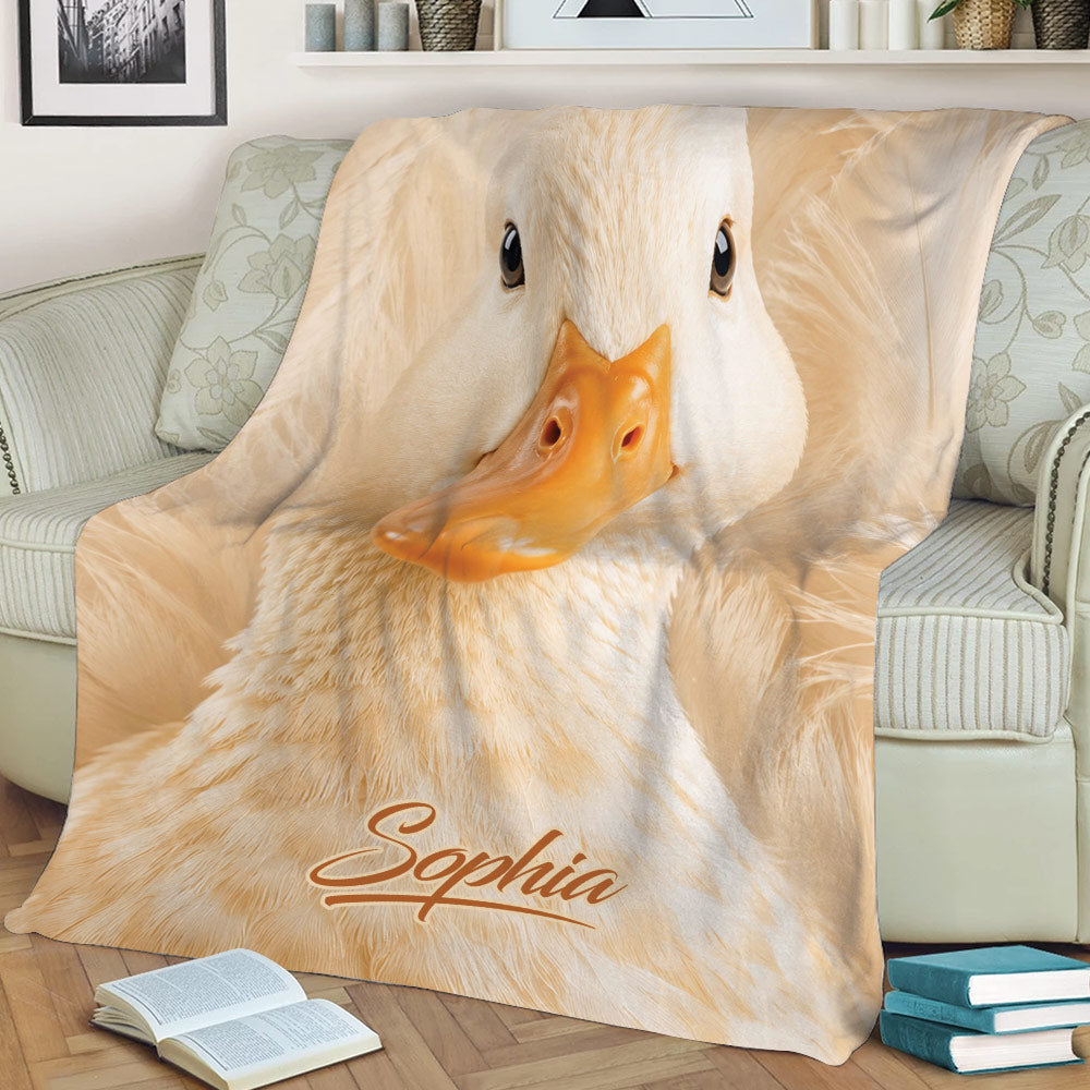 Close-up white duck throw blanket styled across a sofa with warm neutral artwork