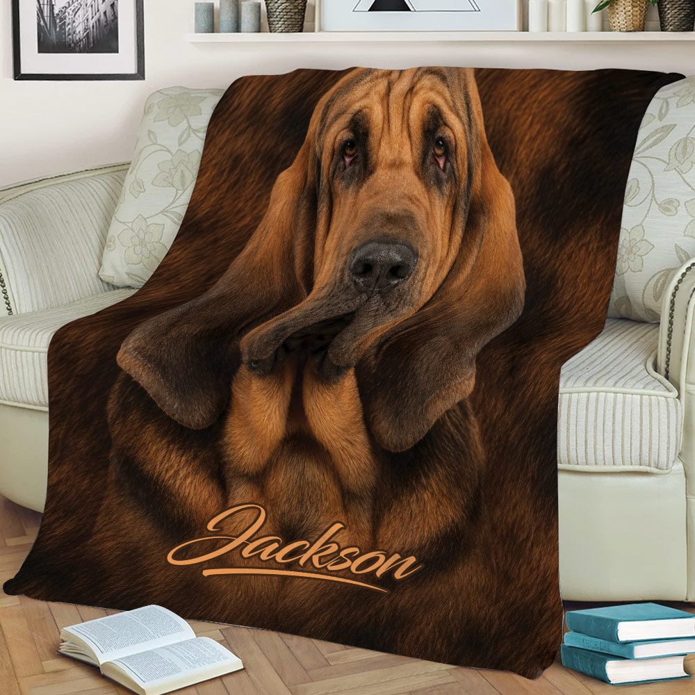 Bloodhound throw blanket styled across a sofa with detailed floppy-eared dog artwork in warm brown tones