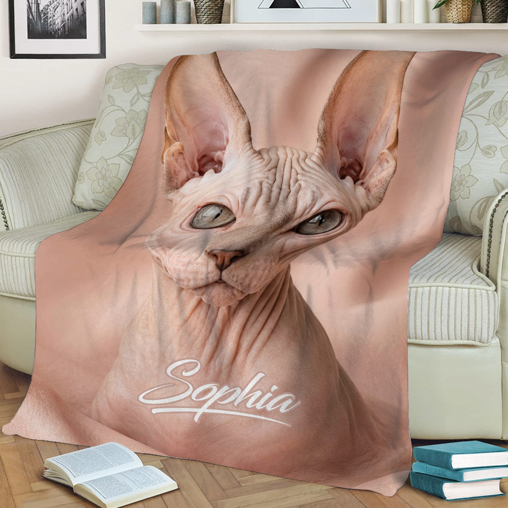 Sphynx cat throw blanket styled on a sofa with close-up hairless cat artwork and blush tones