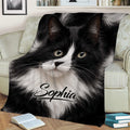 Close-up tuxedo cat blanket displayed on a sofa with bold black-and-white artwork