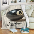 Billiard blanket draped over a sofa with bold black 8-ball artwork in a cozy living room