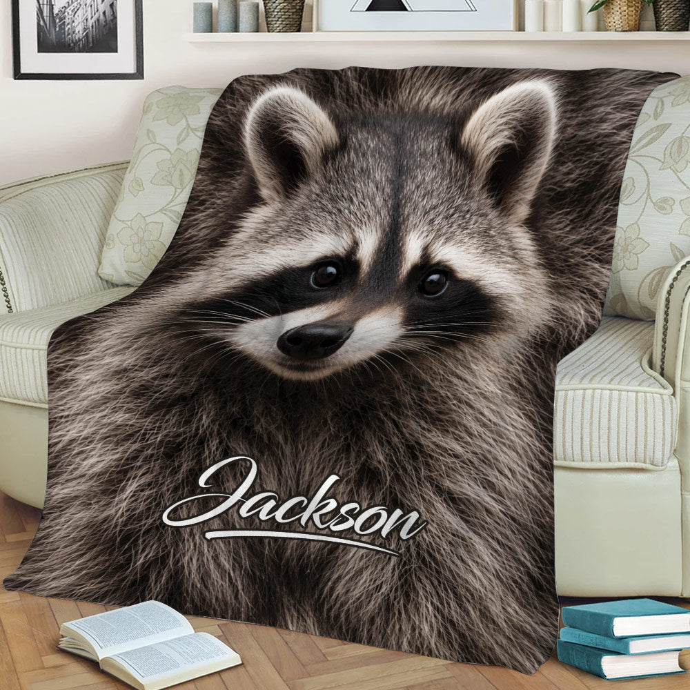 Close-up raccoon blanket displayed across a sofa with wildlife artwork