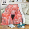 Pink flamingo blanket draped over a sofa with vibrant feather artwork
