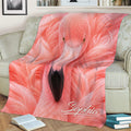Flamingo throw blanket displayed on a couch with bold pink bird artwork