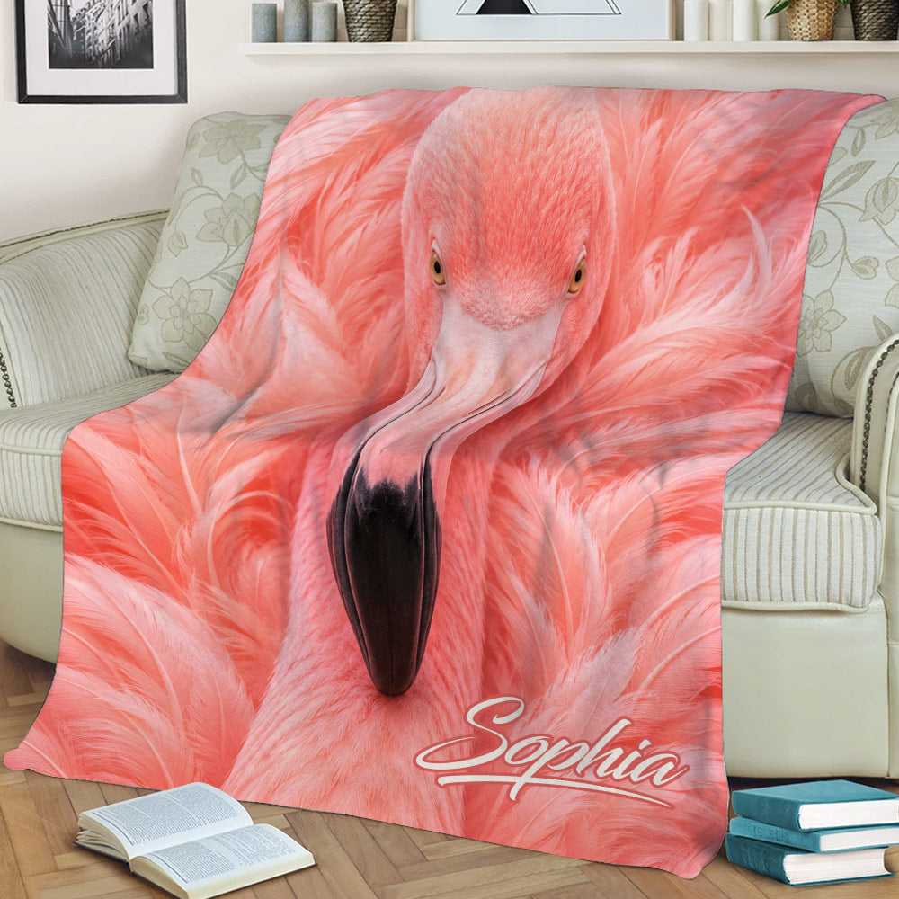 Flamingo throw blanket displayed on a couch with bold pink bird artwork