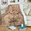 Cozy rabbit throw blanket featuring a close-up tan bunny design draped over a living room sofa