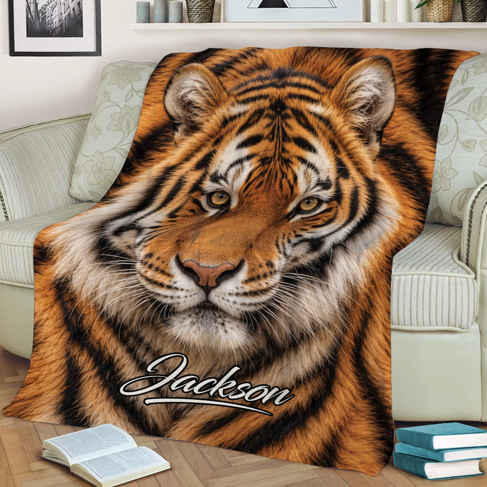 Close-up tiger throw blanket displayed on a sofa with dramatic big cat artwork