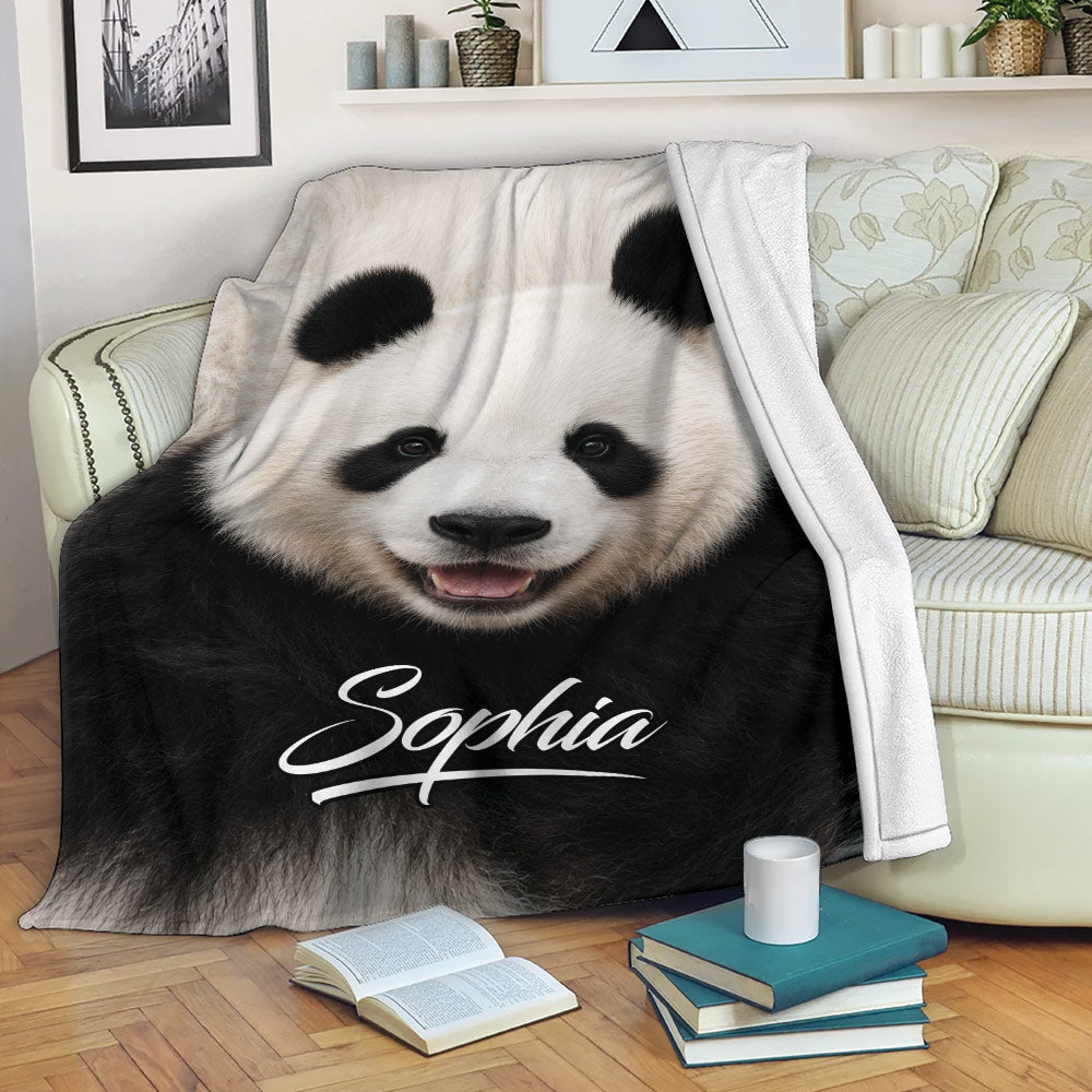 Black and white panda throw blanket styled on a sofa with books and a coffee mug