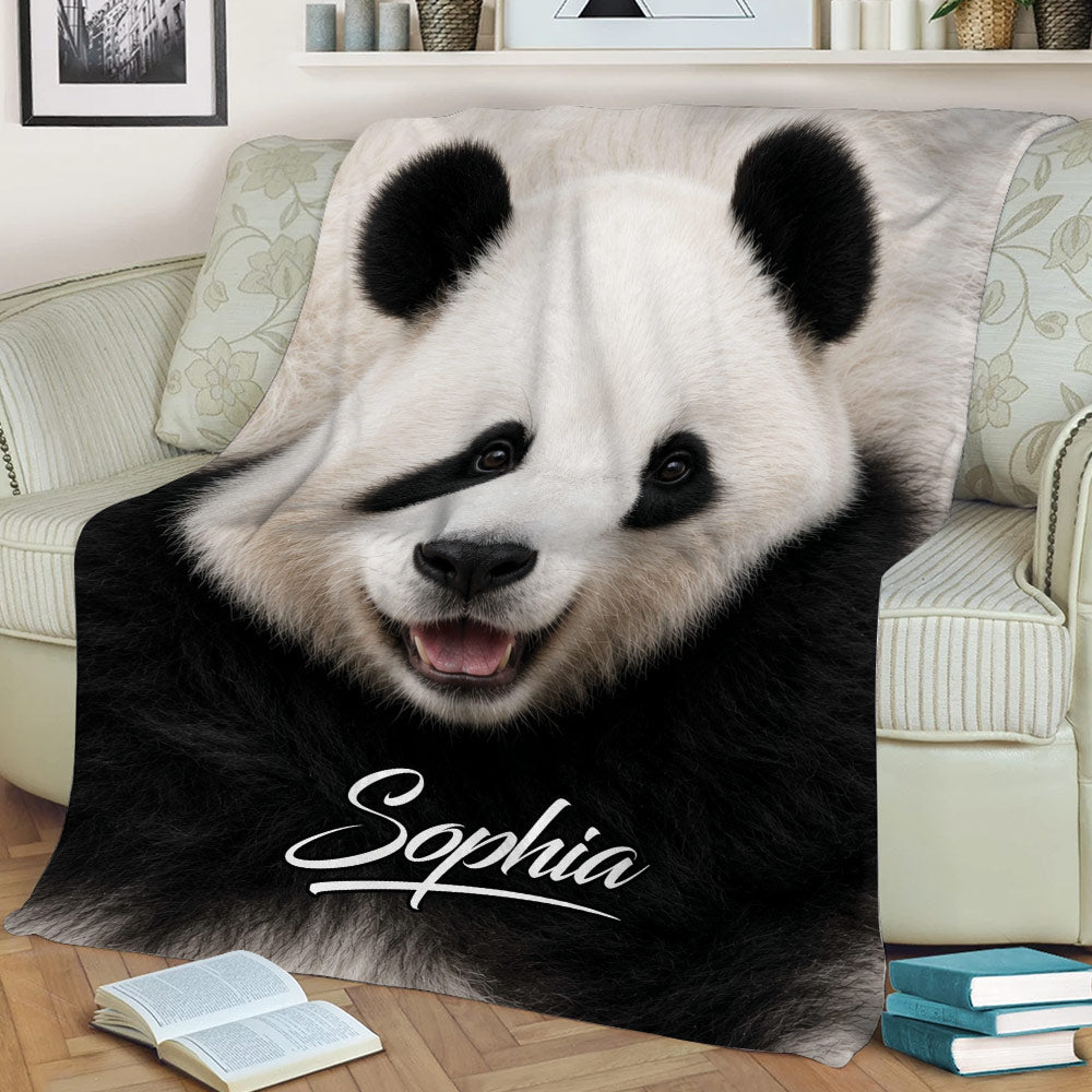 Close-up panda throw blanket displayed across a sofa with cozy living room decor