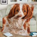 Brittany Spaniel throw blanket displayed on an armchair with a close-up dog design
