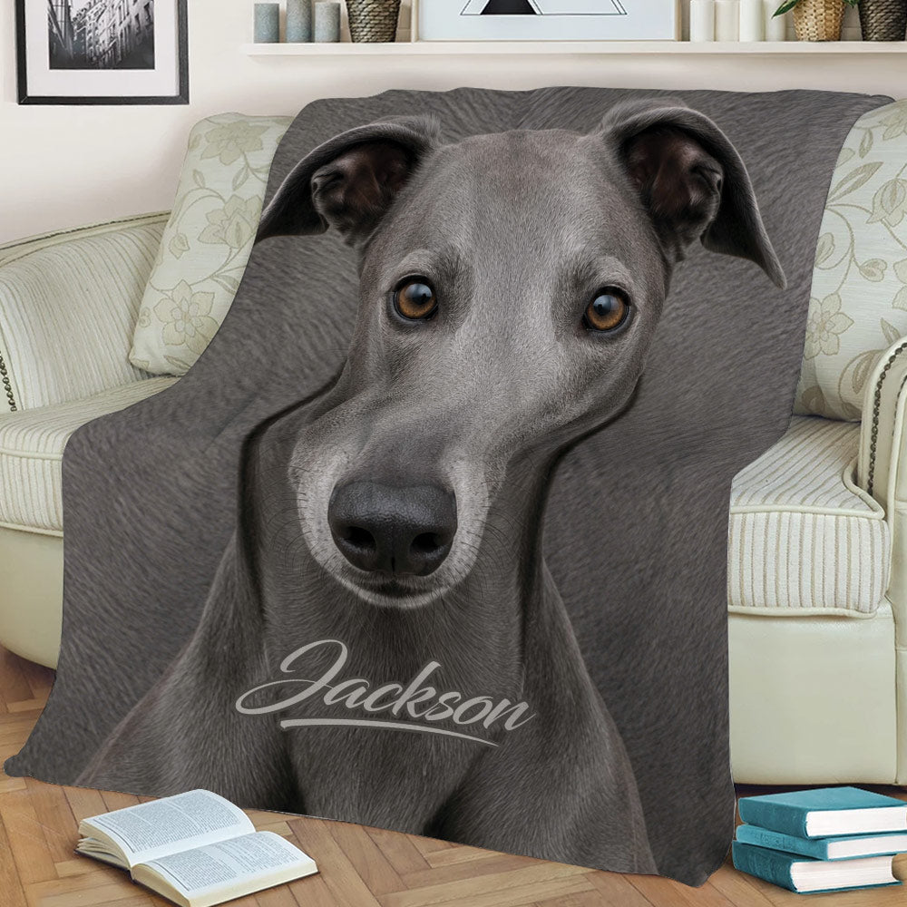 Close view of a greyhound throw blanket spread across a sofa with detailed gray dog artwork