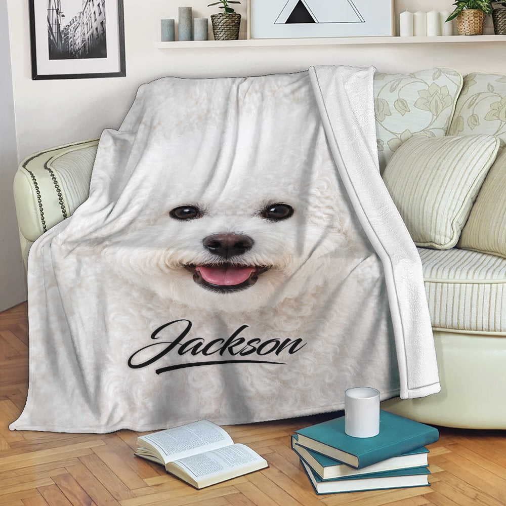 Bichon Frise dog blanket draped over a sofa with books and a cup nearby