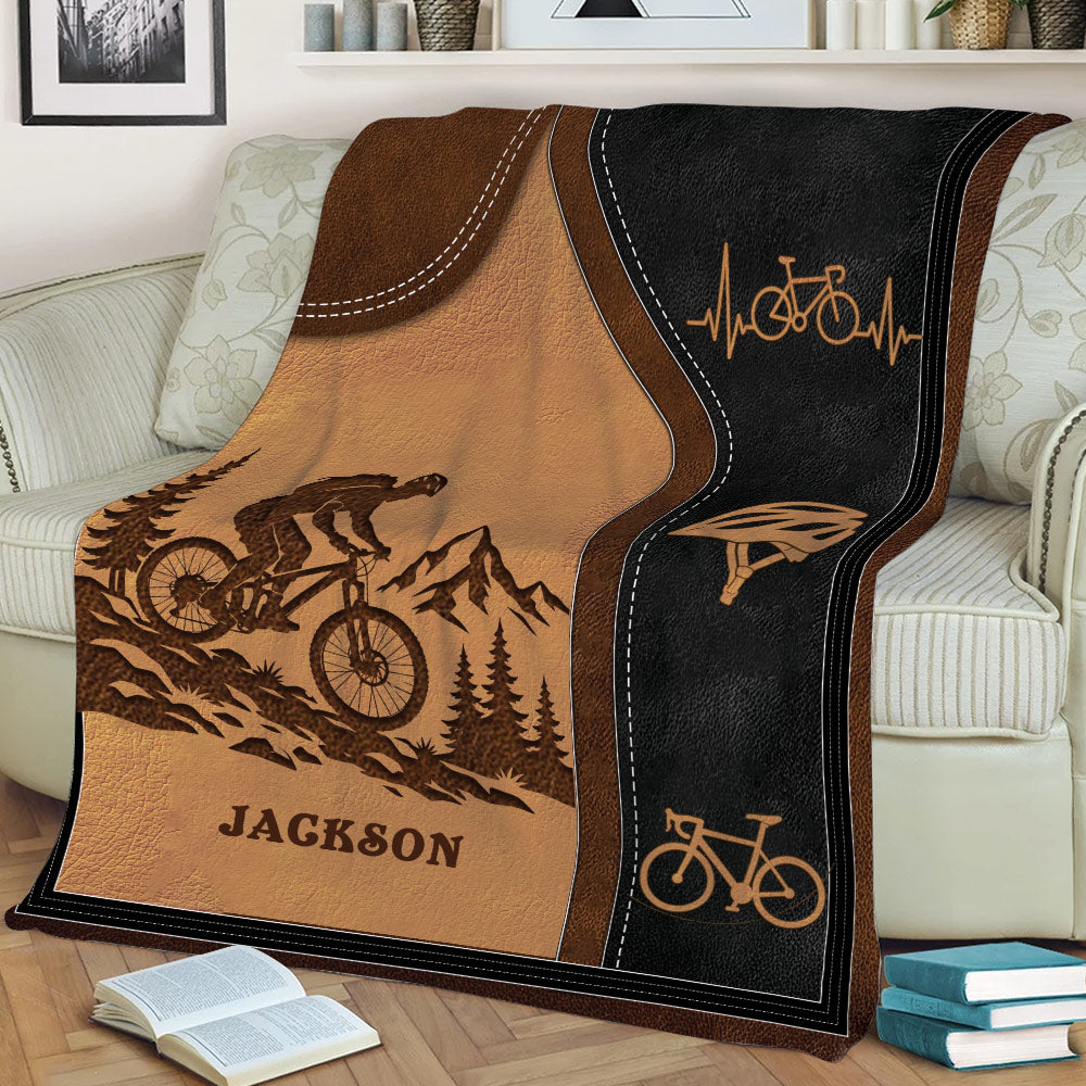 Close view of a custom bicycle blanket with mountain biker scenery, helmet graphics, and bicycle illustrations
