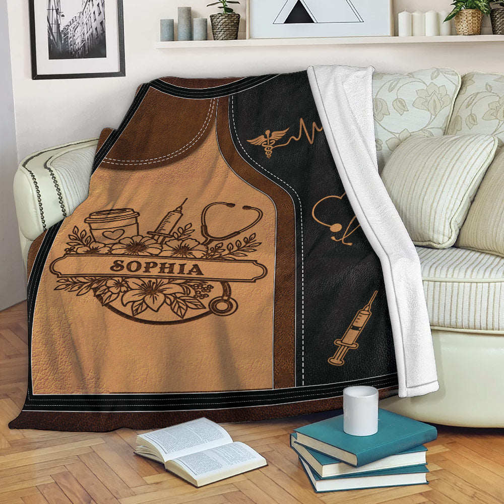 Caregiver blanket displayed on a sofa with healthcare-inspired stethoscope, syringe, and heart design