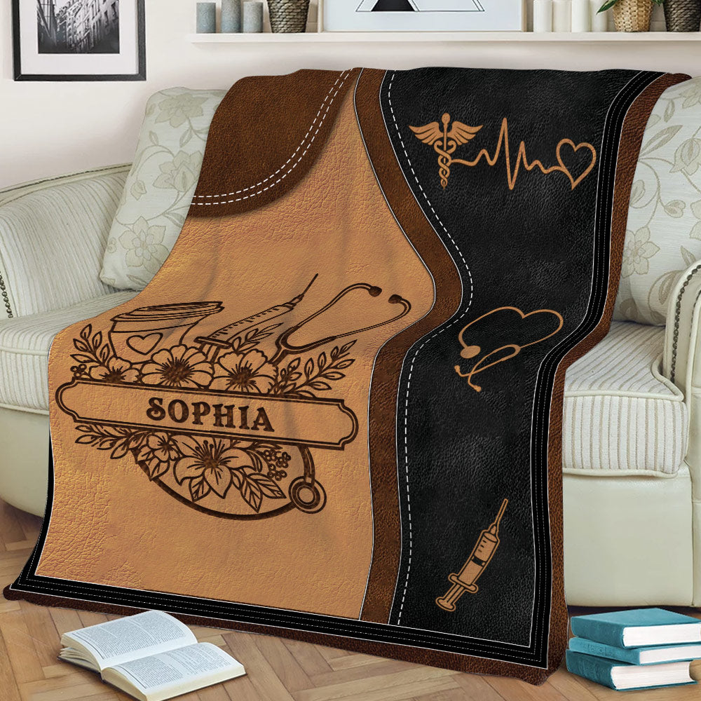Close view of a caregiver throw blanket featuring medical symbols, floral accents, and warm brown artwork