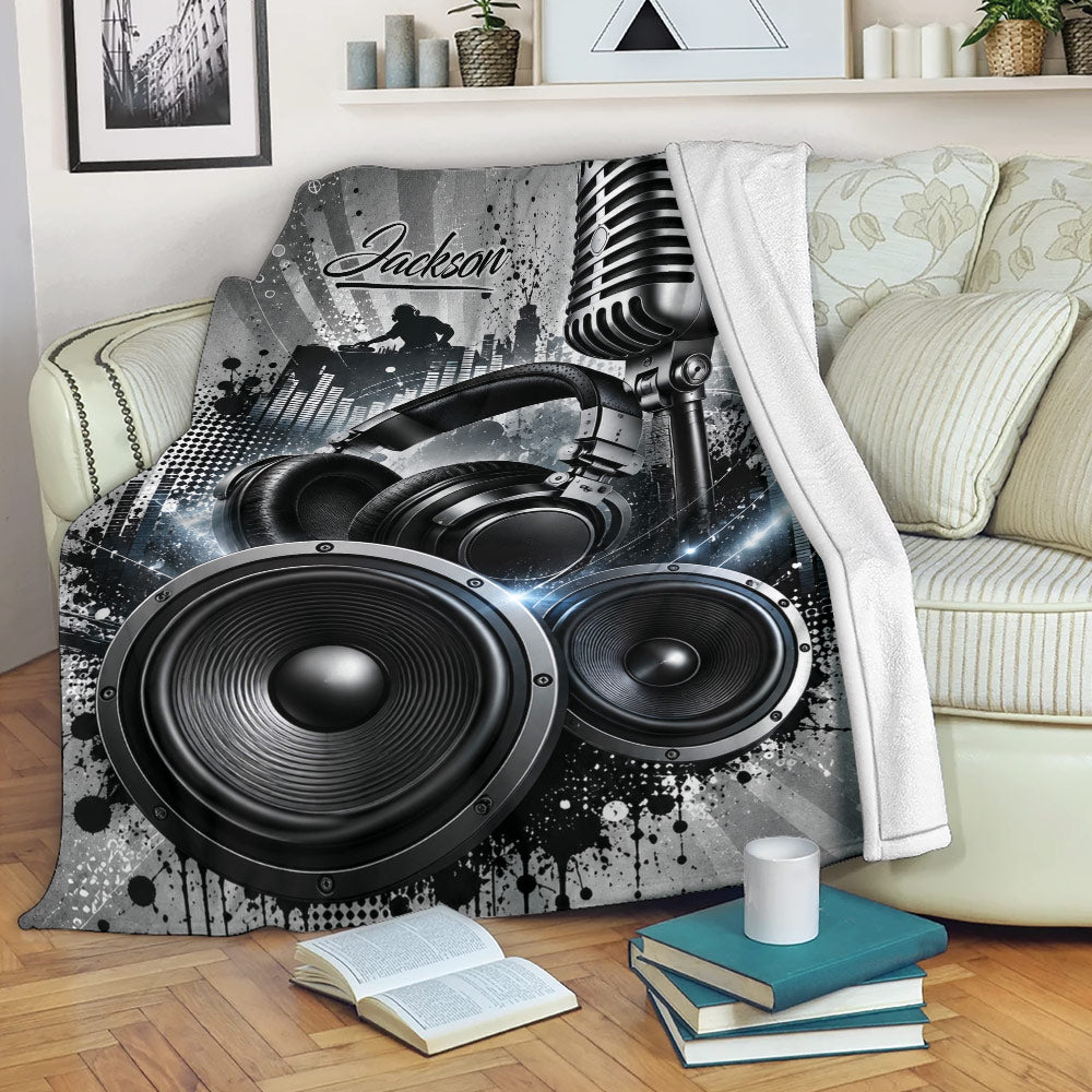 DJ throw blanket displayed on a sofa with microphone, headphones, speakers, and urban music studio artwork