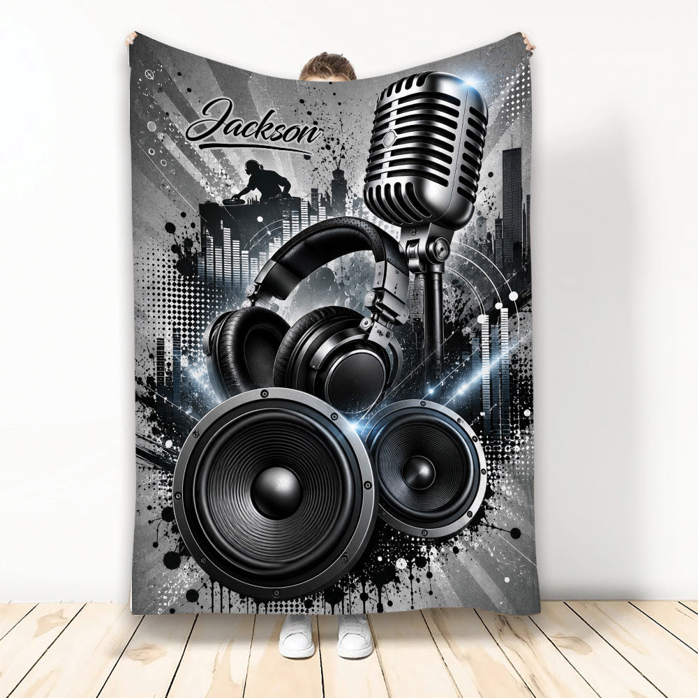 DJ throw blanket with microphone, headphones, speakers, turntable silhouette, and dramatic black and silver music artwork