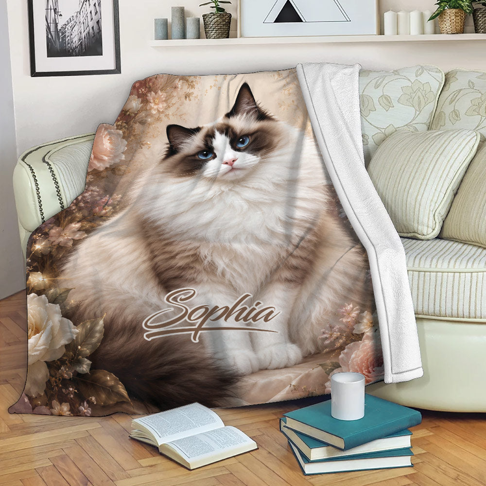 Ragdoll cat blanket displayed on a sofa with a fluffy blue-eyed cat and floral design