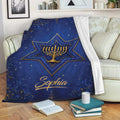 Hanukkah throw blanket draped over a sofa with a blue menorah and Star of David design