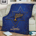 Decorative Hanukkah blanket displayed on a couch with a gold menorah and blue star artwork