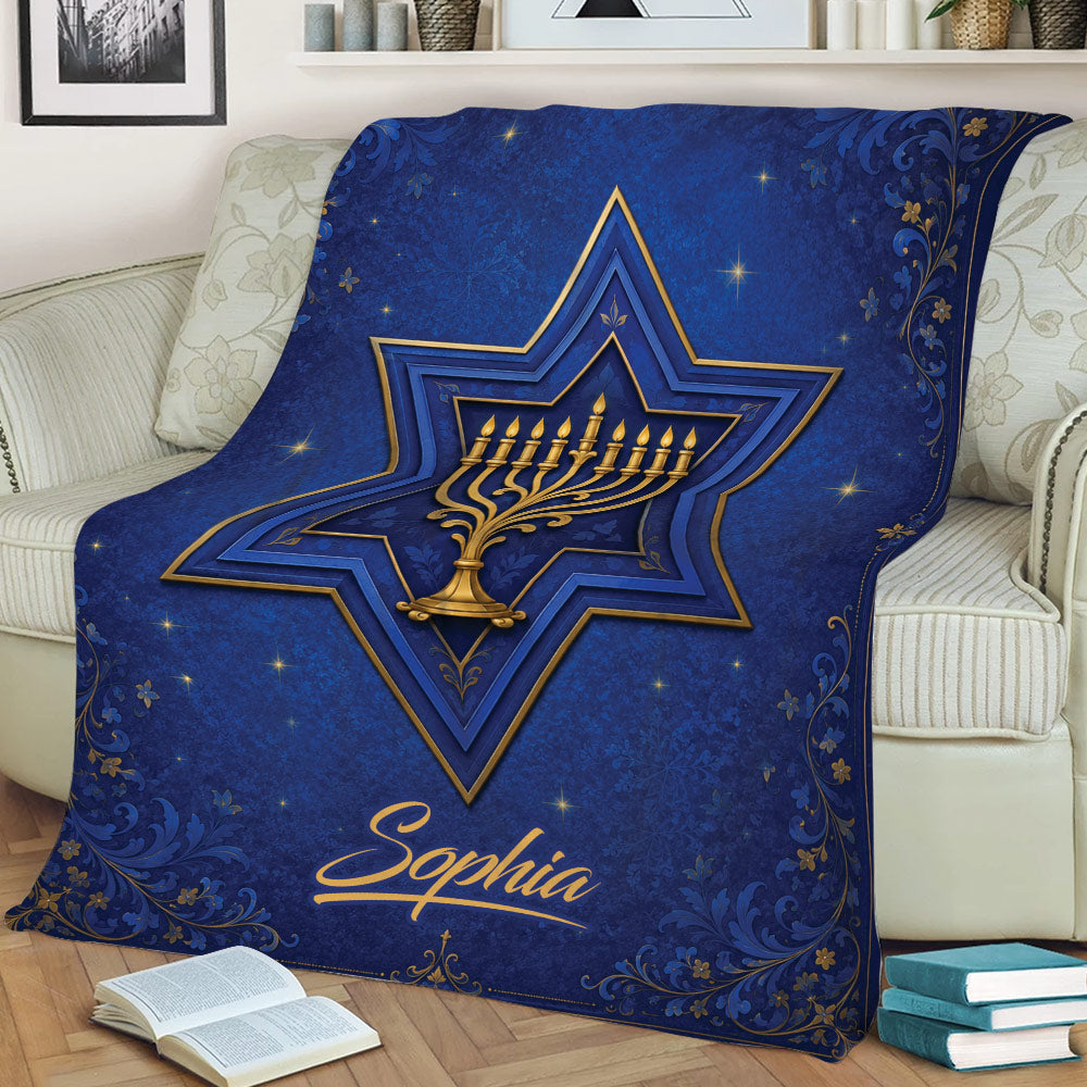 Decorative Hanukkah blanket displayed on a couch with a gold menorah and blue star artwork
