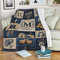 Hanukkah throw blanket styled on a sofa with menorah, dreidel, gift, and Jewish holiday motifs