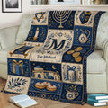 Close view of a Hanukkah blanket with menorah, Torah scrolls, dreidel, gifts, and festive Jewish artwork