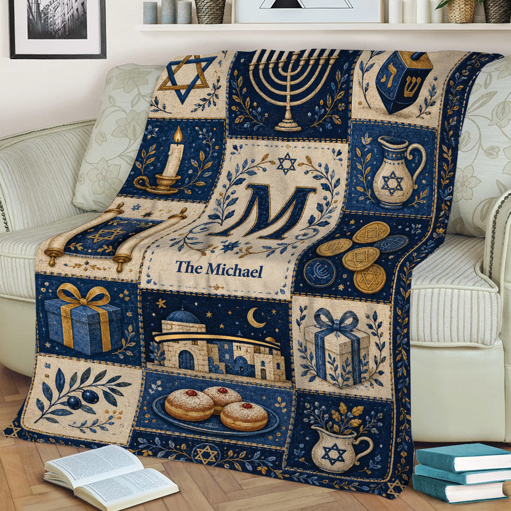 Close view of a Hanukkah blanket with menorah, Torah scrolls, dreidel, gifts, and festive Jewish artwork