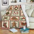 Vintage Christmas blanket draped over a sofa with Santa, presents, ornaments, stockings, and holiday tree panels