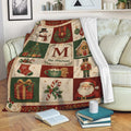 Christmas throw blanket displayed on a sofa with Santa, gifts, stockings, ornaments, and festive holiday scenes