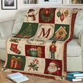 Close view of a Christmas blanket draped over a sofa with snowman, wreath, tree, gingerbread house, and Santa