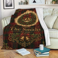 Christmas throw blanket draped over a sofa with tartan pattern, wreath, bells, and holiday greenery