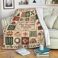 Custom Christmas blanket displayed on a sofa with festive patchwork holiday artwork